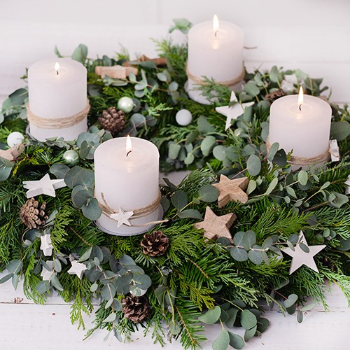 Adventskranz mit weißen Kerzen, Tannenzweigen und weihnachtlicher Dekoration, festliche Stimmung zur Adventszeit und Weihnachten