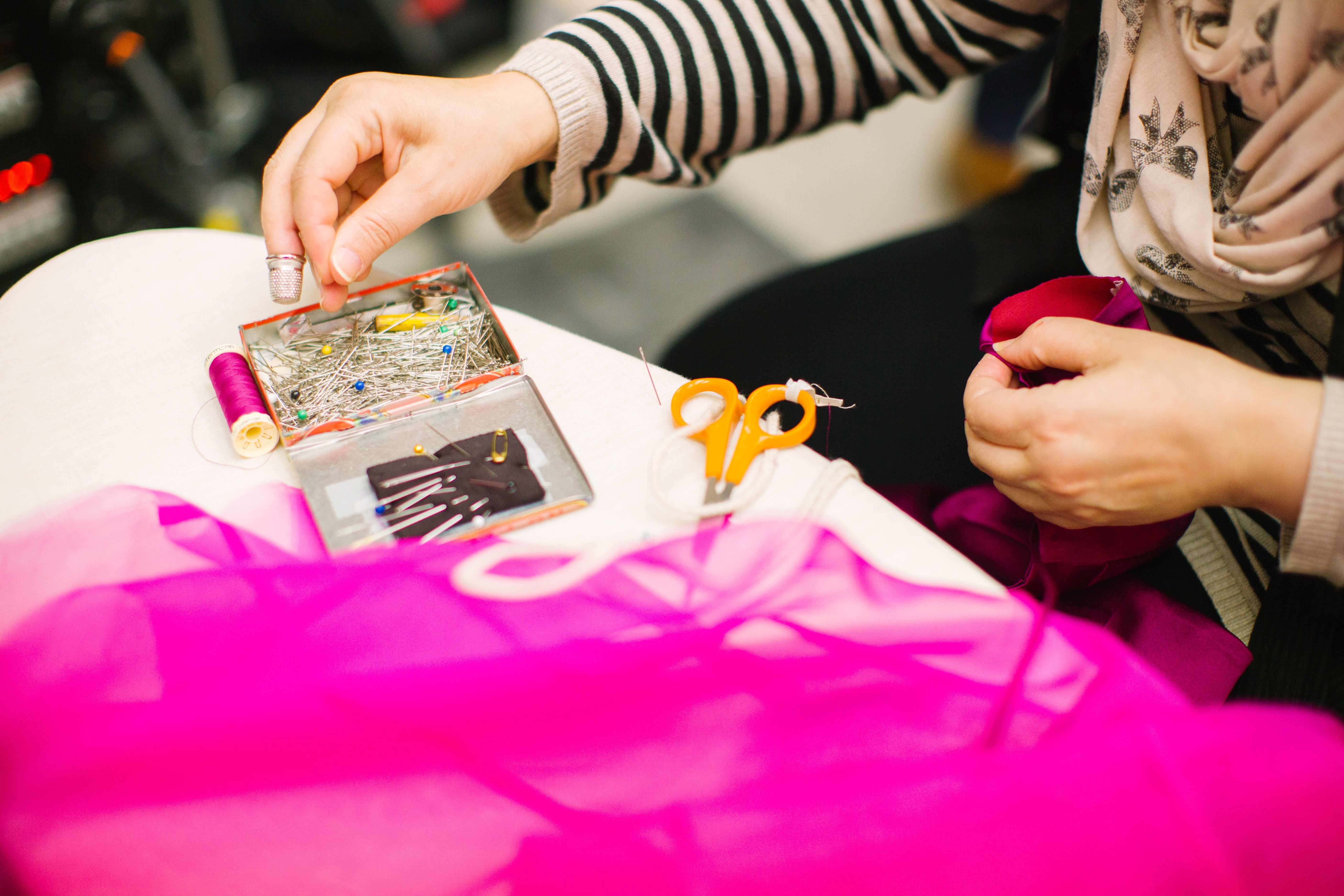 Person bastelt mit Stoff und Schere am Tisch, kreative Handarbeit und DIY Gestaltung mit bunten Materialien im Workshop oder Hobbybereich